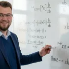 Fokusert mattelærer ved tavlen forklarer komplekse formler og funksjoner
